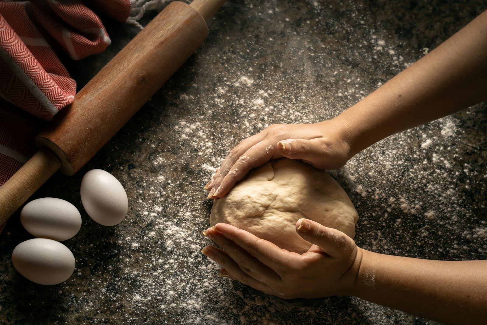 Manos de maestro pizzaiolo amasando masa napolitana