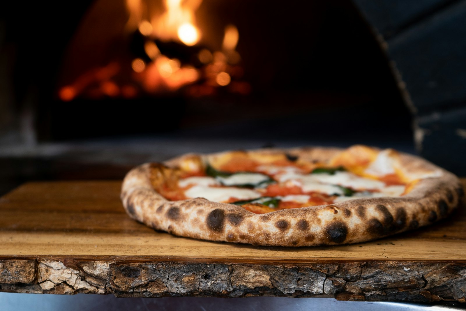 Pizza napolitana saliendo del horno de leña